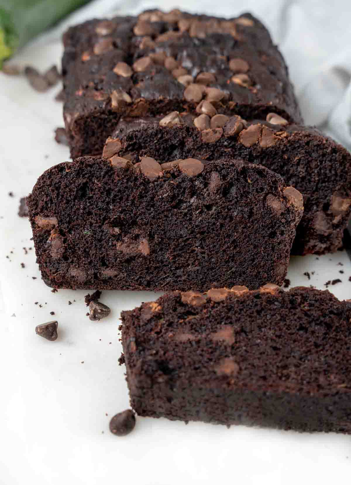 chocolate zucchini bread sliced on white cutting board.