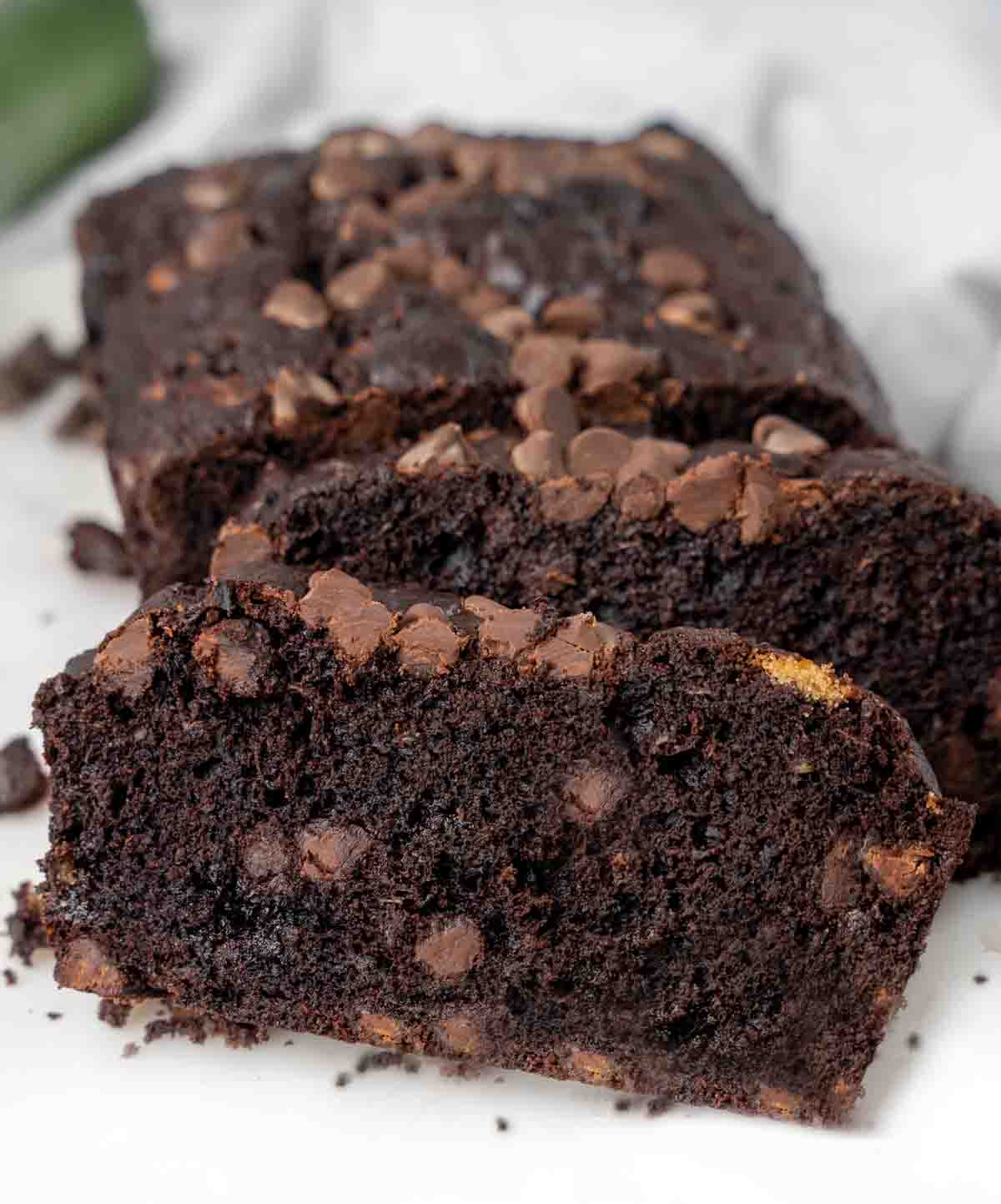 chocolate zucchini bread sliced on white cutting board.