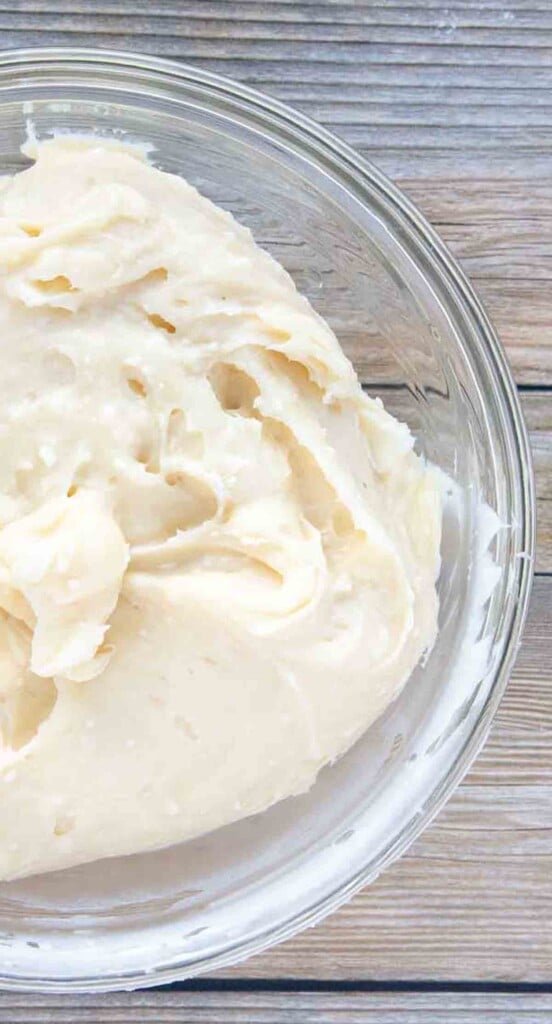 overhead image of cream cheese frosting in a glass bowl