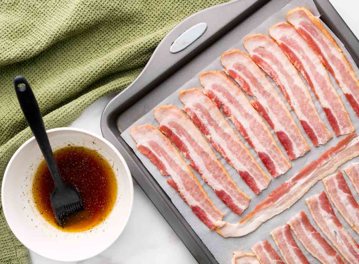 bacon on parchment lined baking sheet next to candy mixture