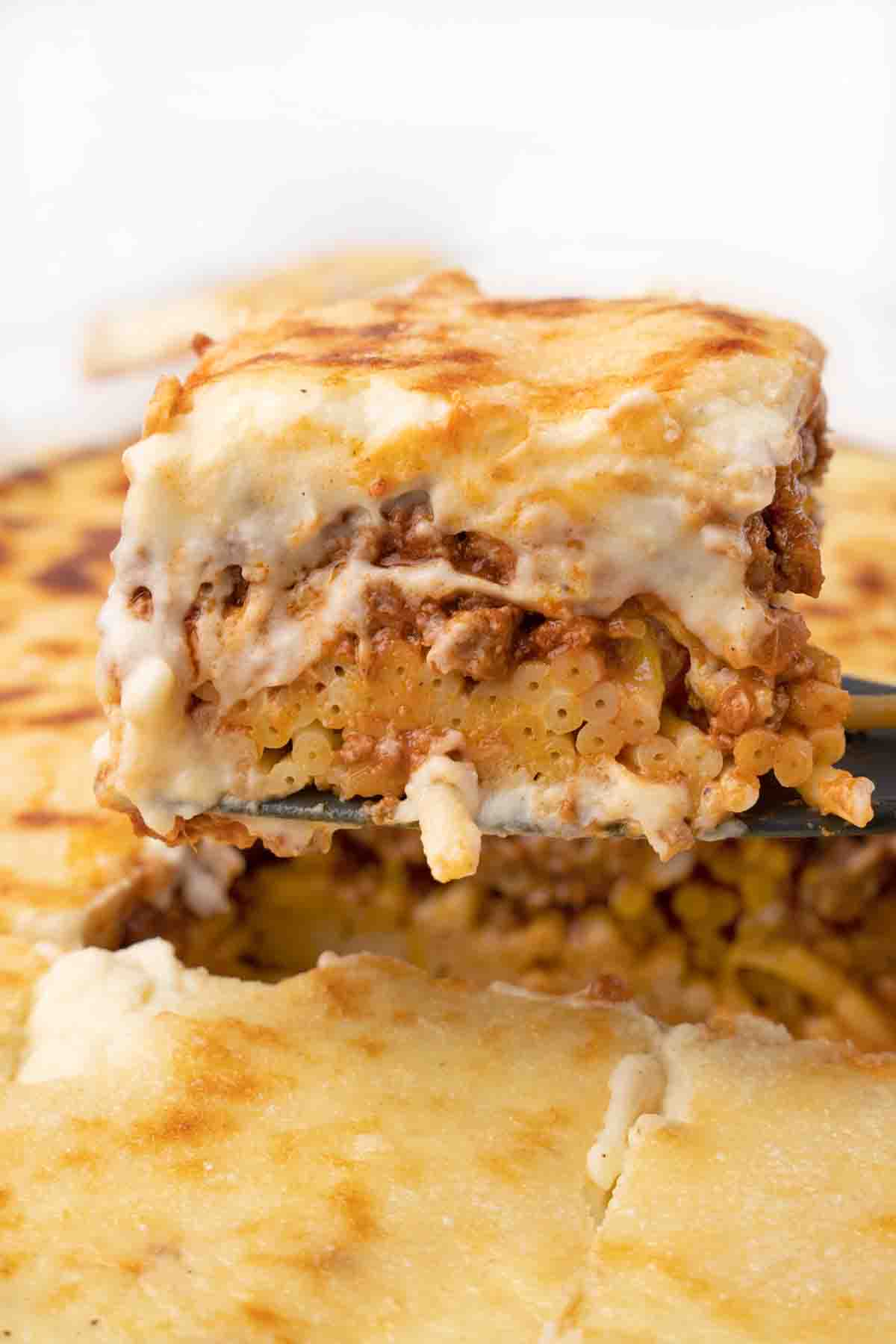 piece of pastitsio being taken out of pan