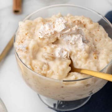 rice pudding in a dessert glass with a spoon in the pudding