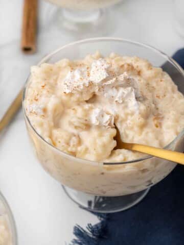 rice pudding in a dessert glass with a spoon in the pudding
