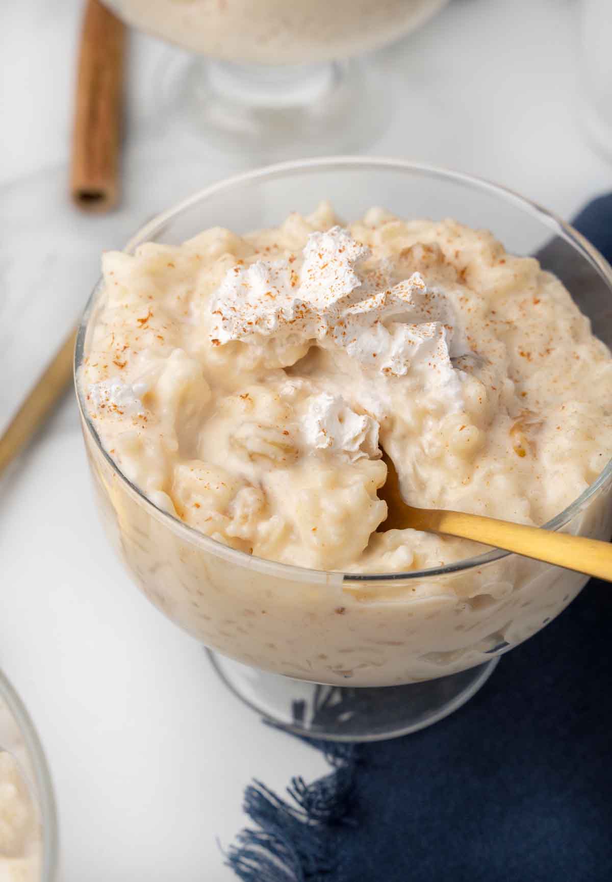 rice pudding in a dessert glass with a spoon in the pudding