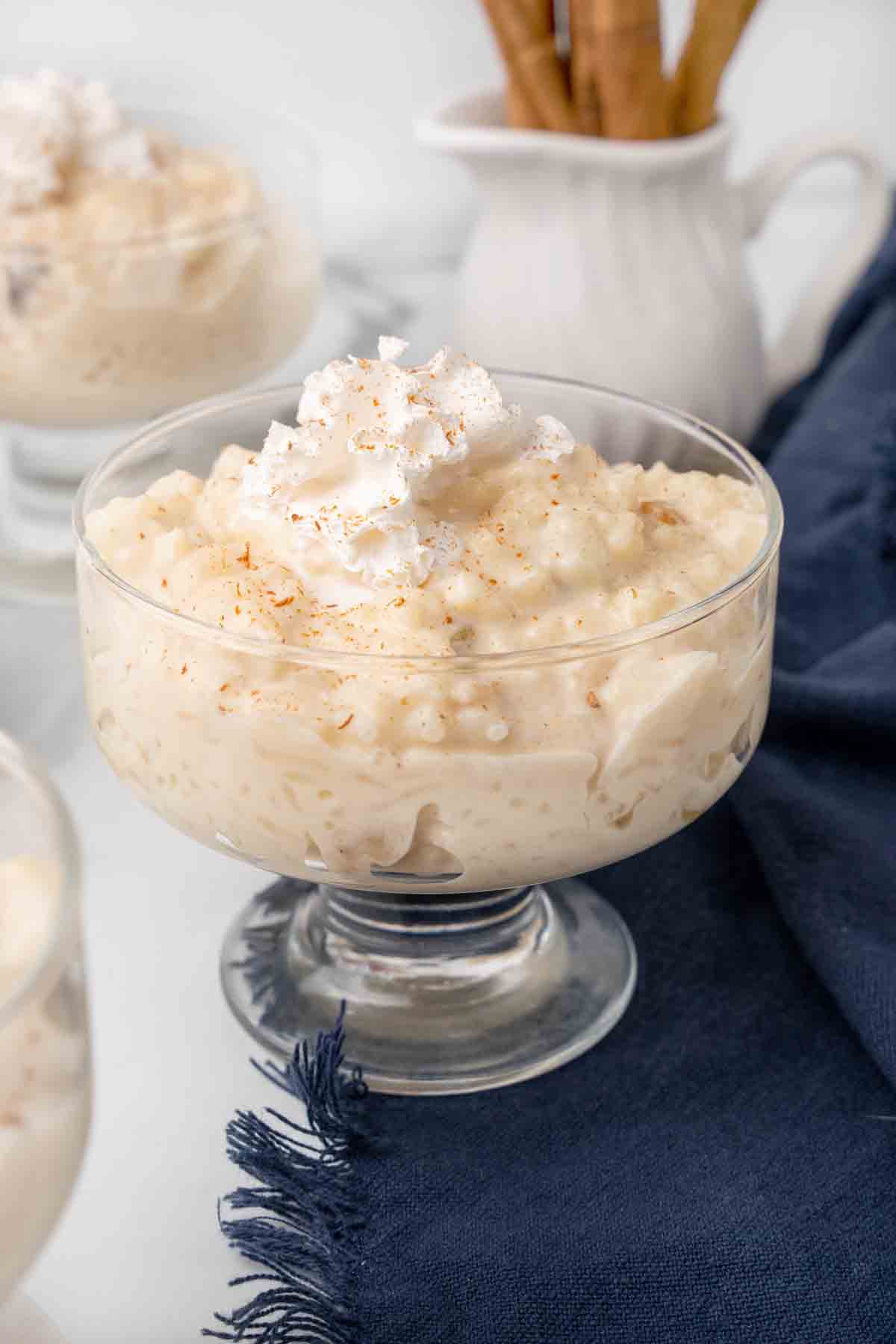 rice pudding in a dessert glass topped with whipped cream