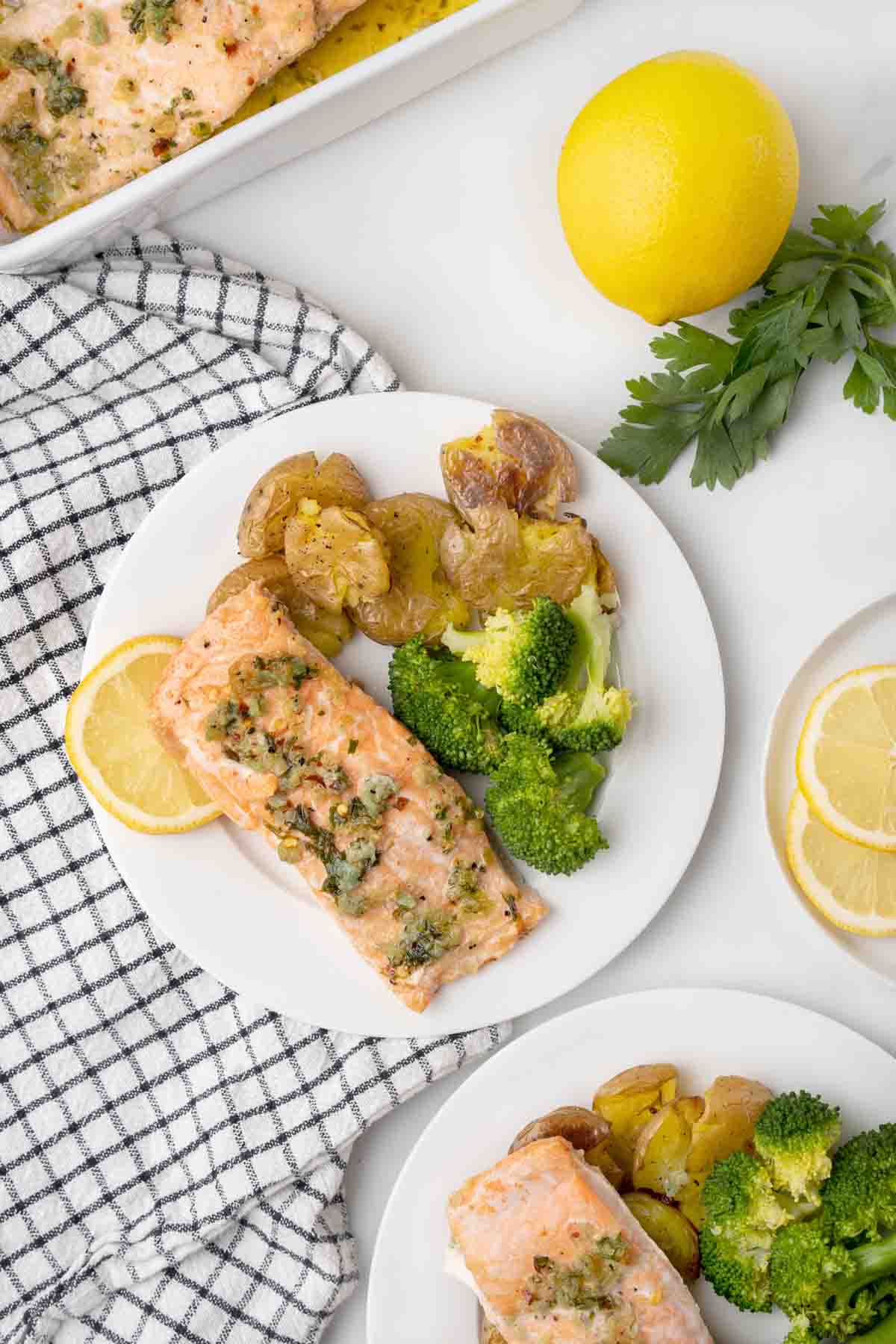 garlic butter salmon with potatoes and broccoli on a white plate