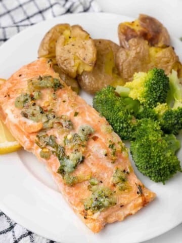 garlic butter salmon with broccoli and potatoes on a white plate