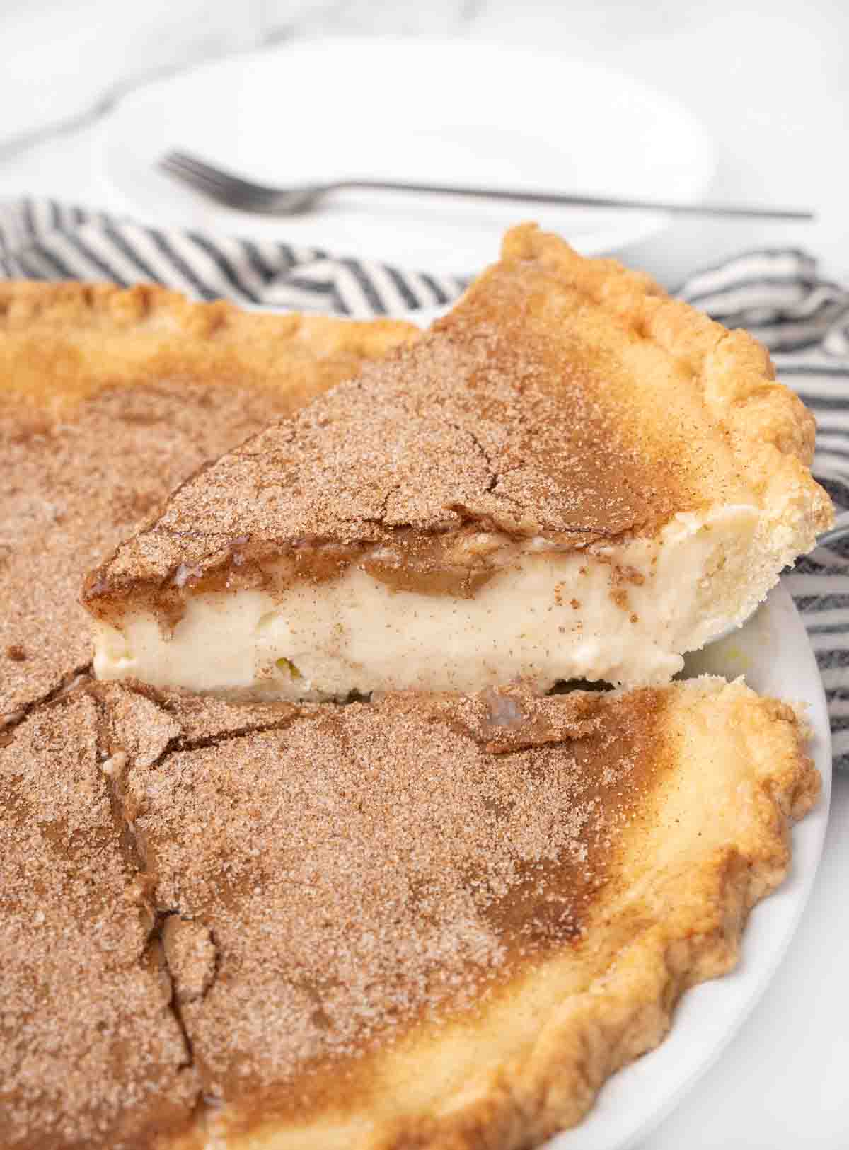 slice of sugar pie on a spatula being taken out of whole pie.