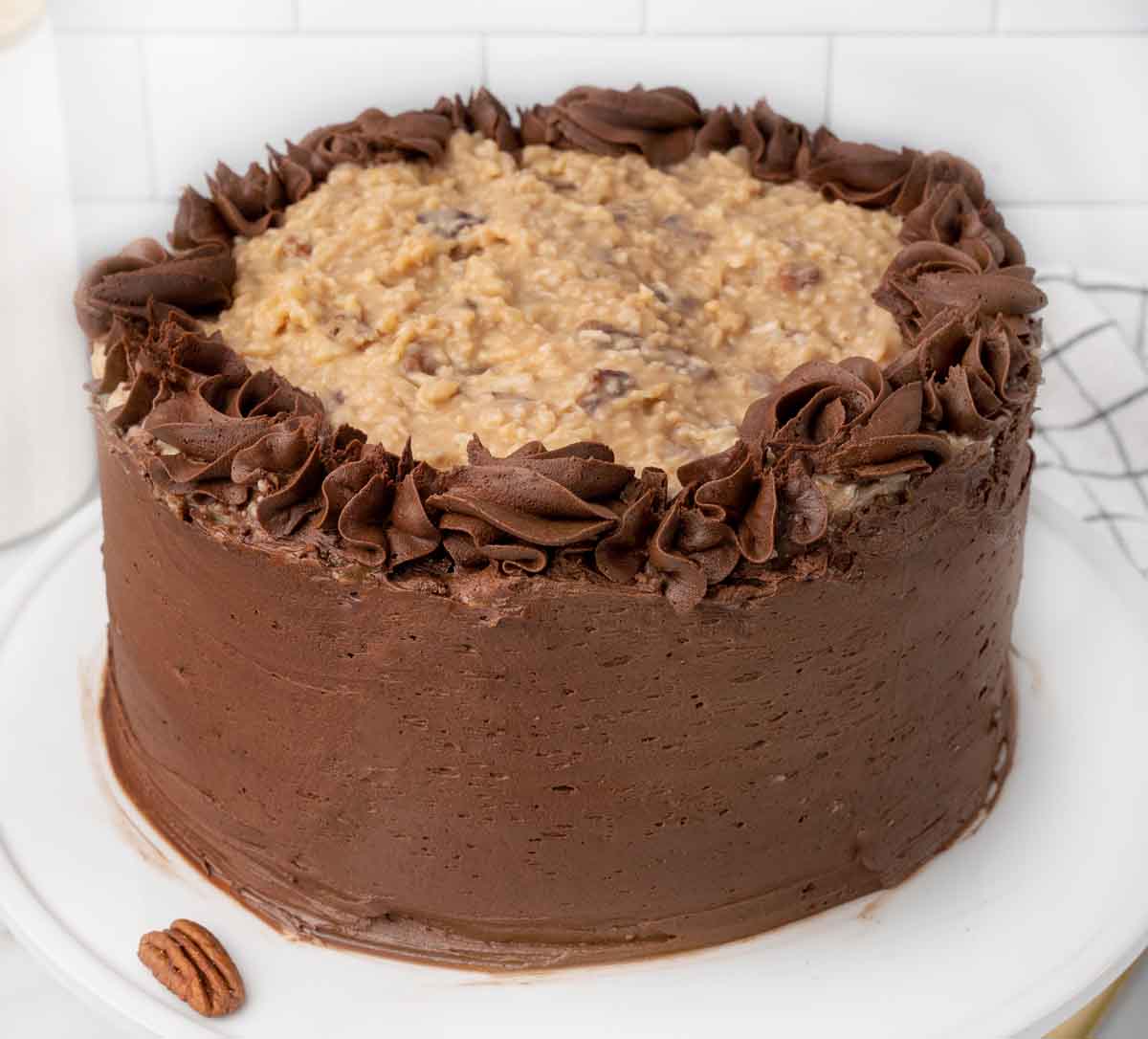 Whole German Chocolate Cake on white cake stand.