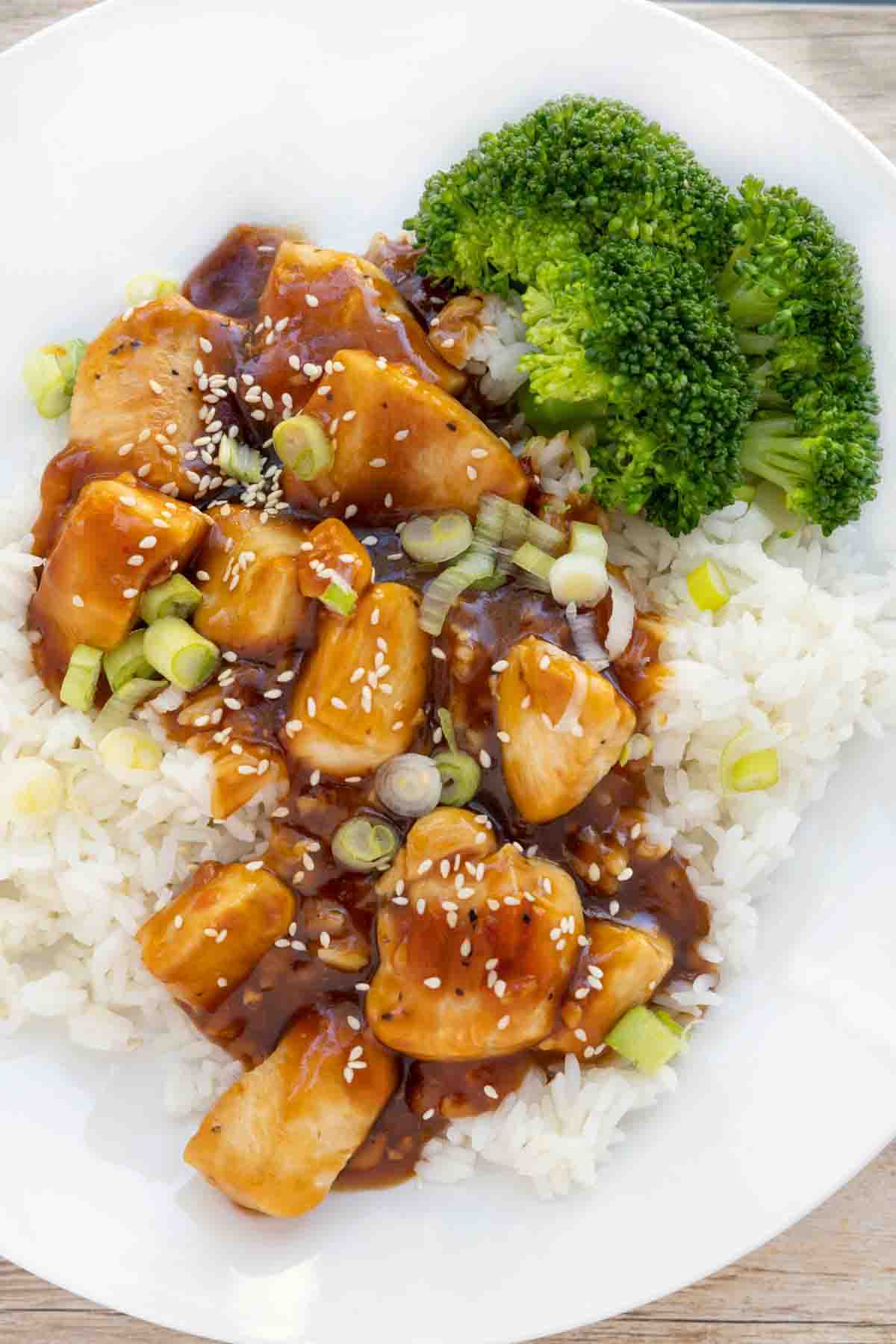 Korean BBQ Chicken over jasmine rice on a white plate with broccoli.