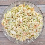shredded cabbage with coleslaw dressing in a glass bowl.