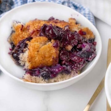 Blueberry cobbler in a white bowl.
