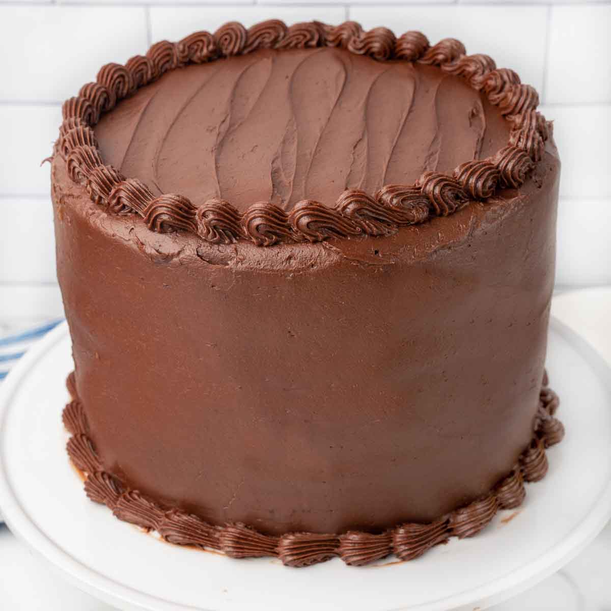 Whole chocolate cake frosted and decorated with chocolate cream cheese frosting.