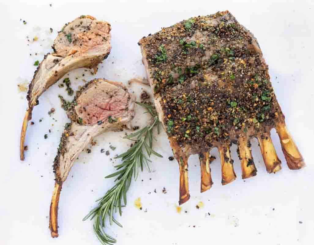 Rack of lamb with two chops on a white cutting board