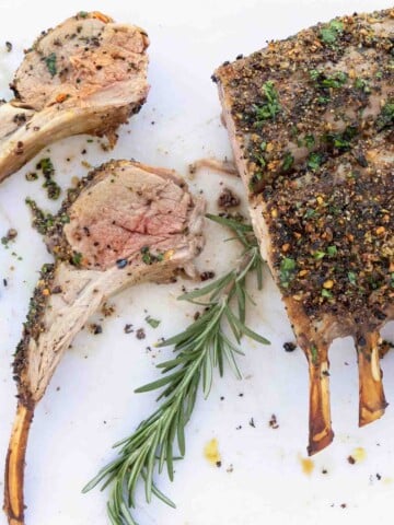 Rack of lamb with two chops on a white cutting board
