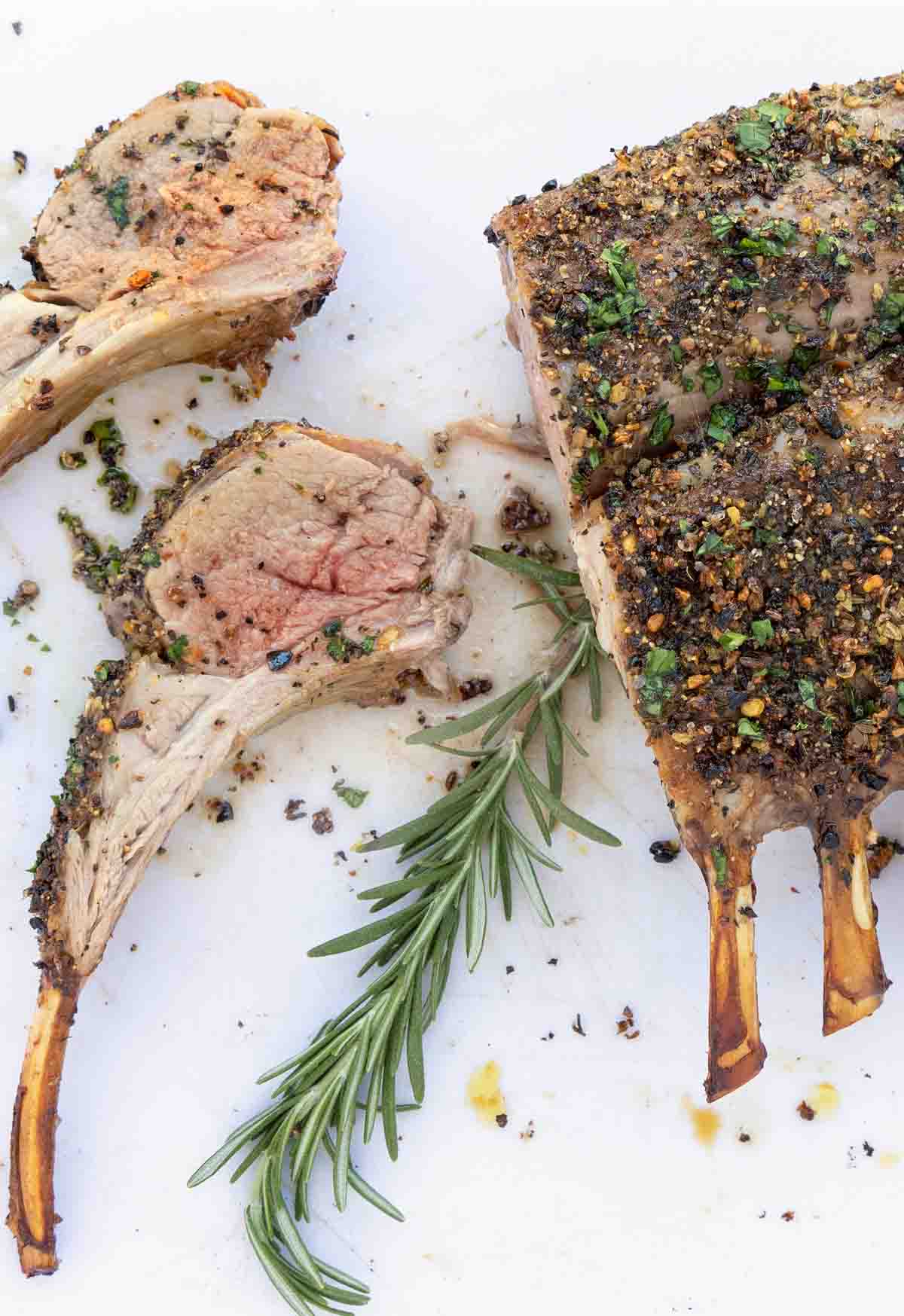 Rack of lamb with two chops on a white cutting board