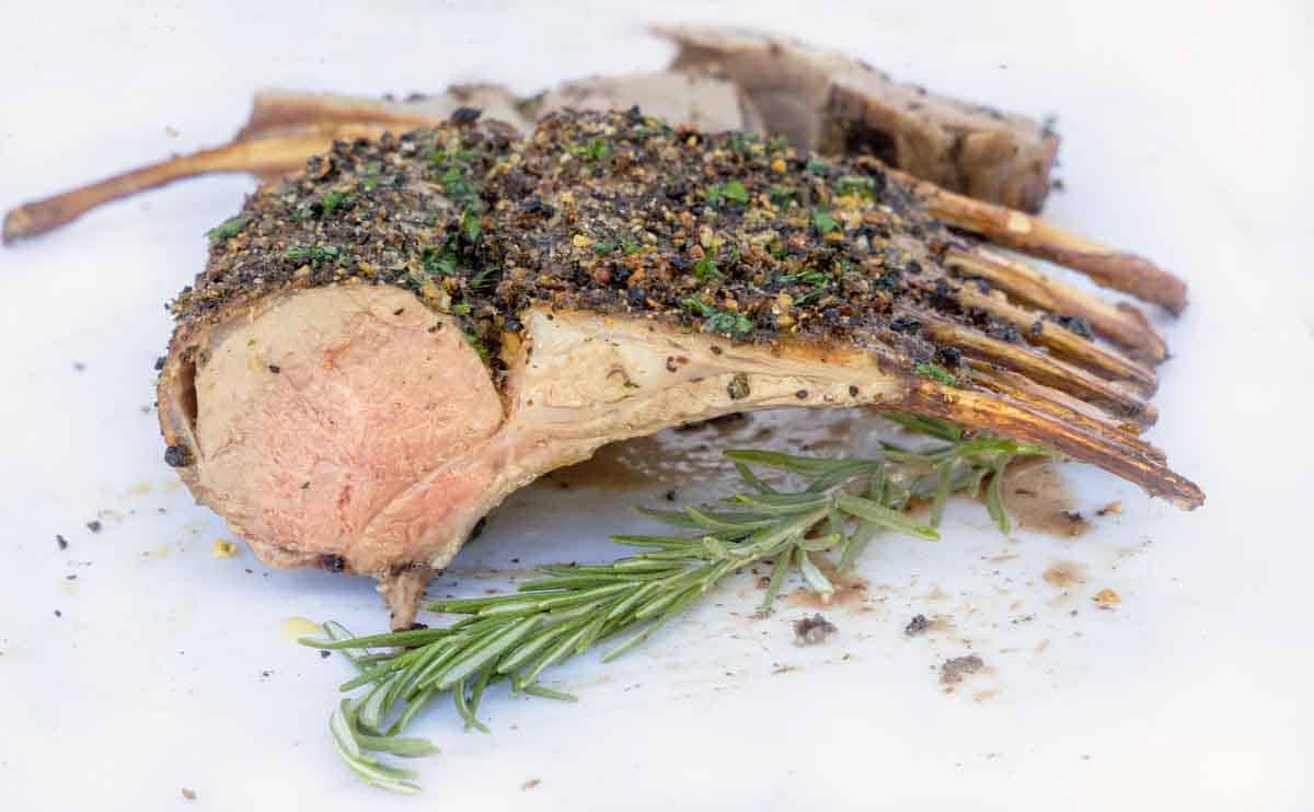 rack of lamb view of cut side with sprig of rosemary.