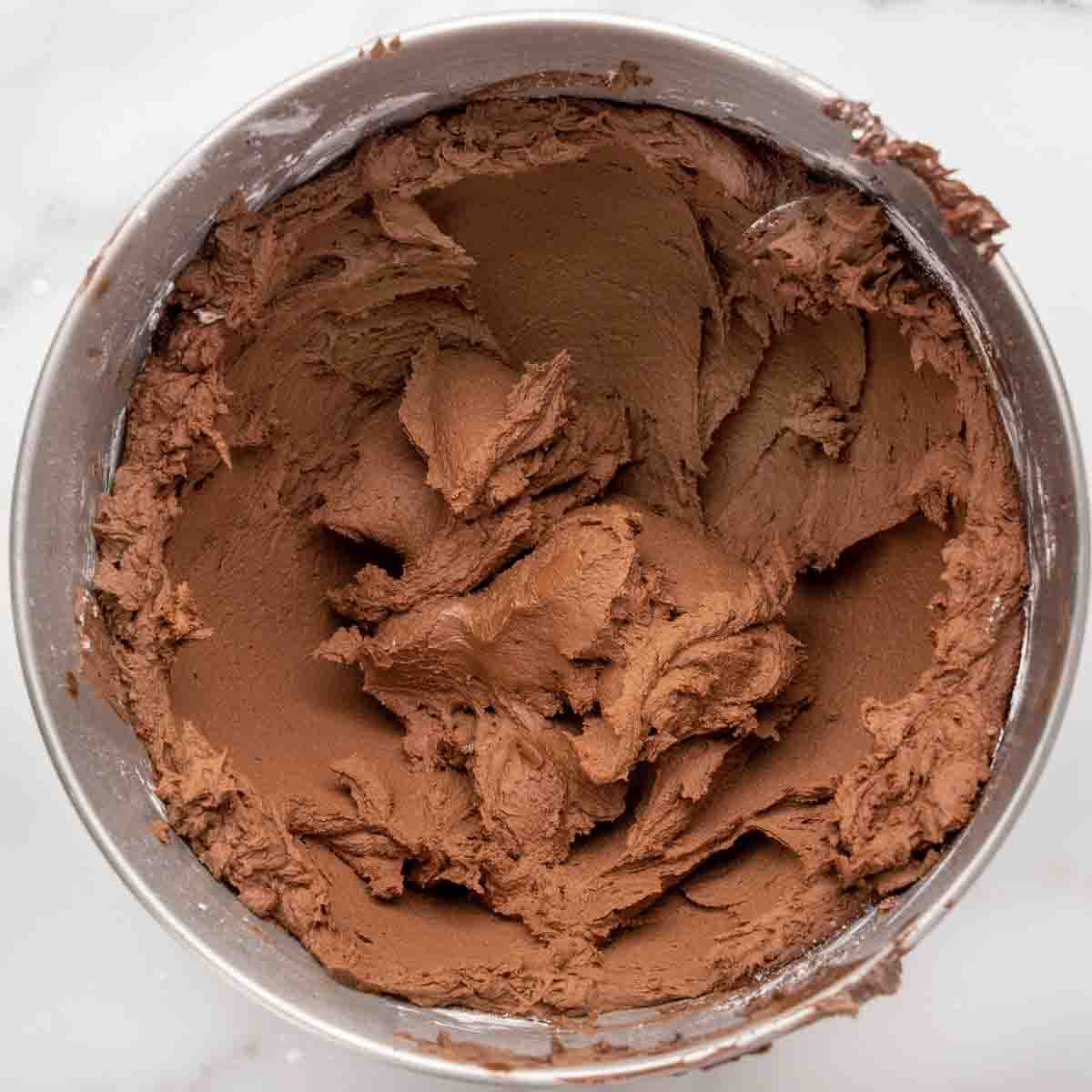 whipped chocolate buttercream frosting in mixing bowl.