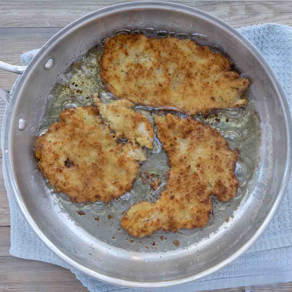 cooking breaded cutlets in frying pan.