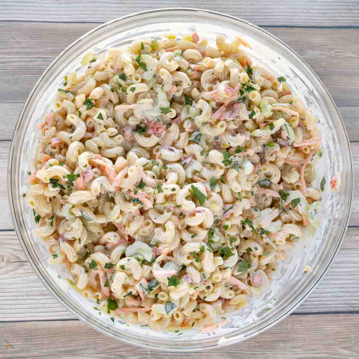 Macaroni salad in a glass bowl.