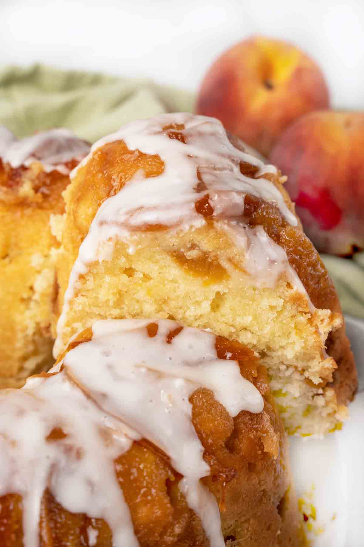 slice of peach cobbler pound cake being taken out of the whole cake.