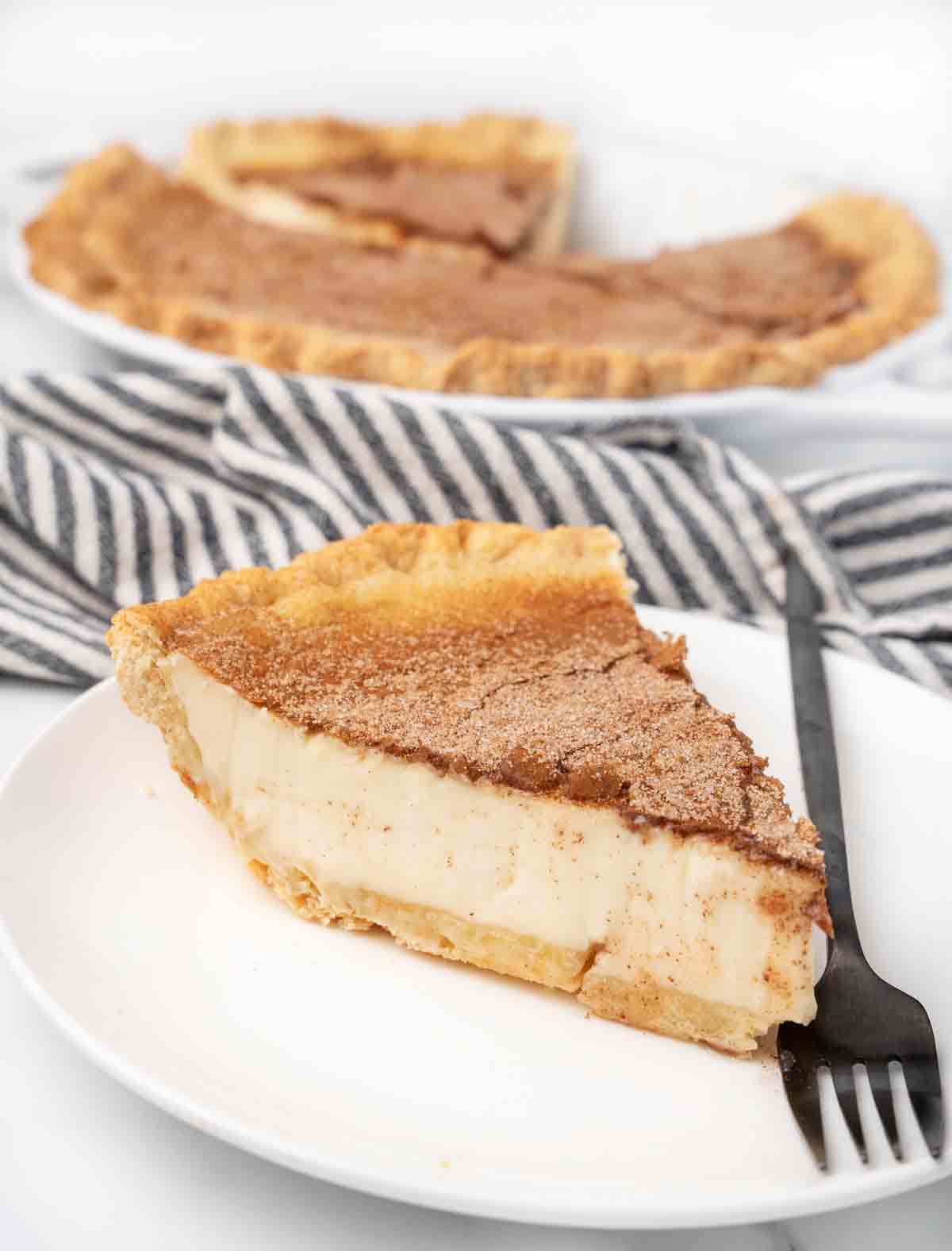 slice of sugar pie on a white plate with a fork.