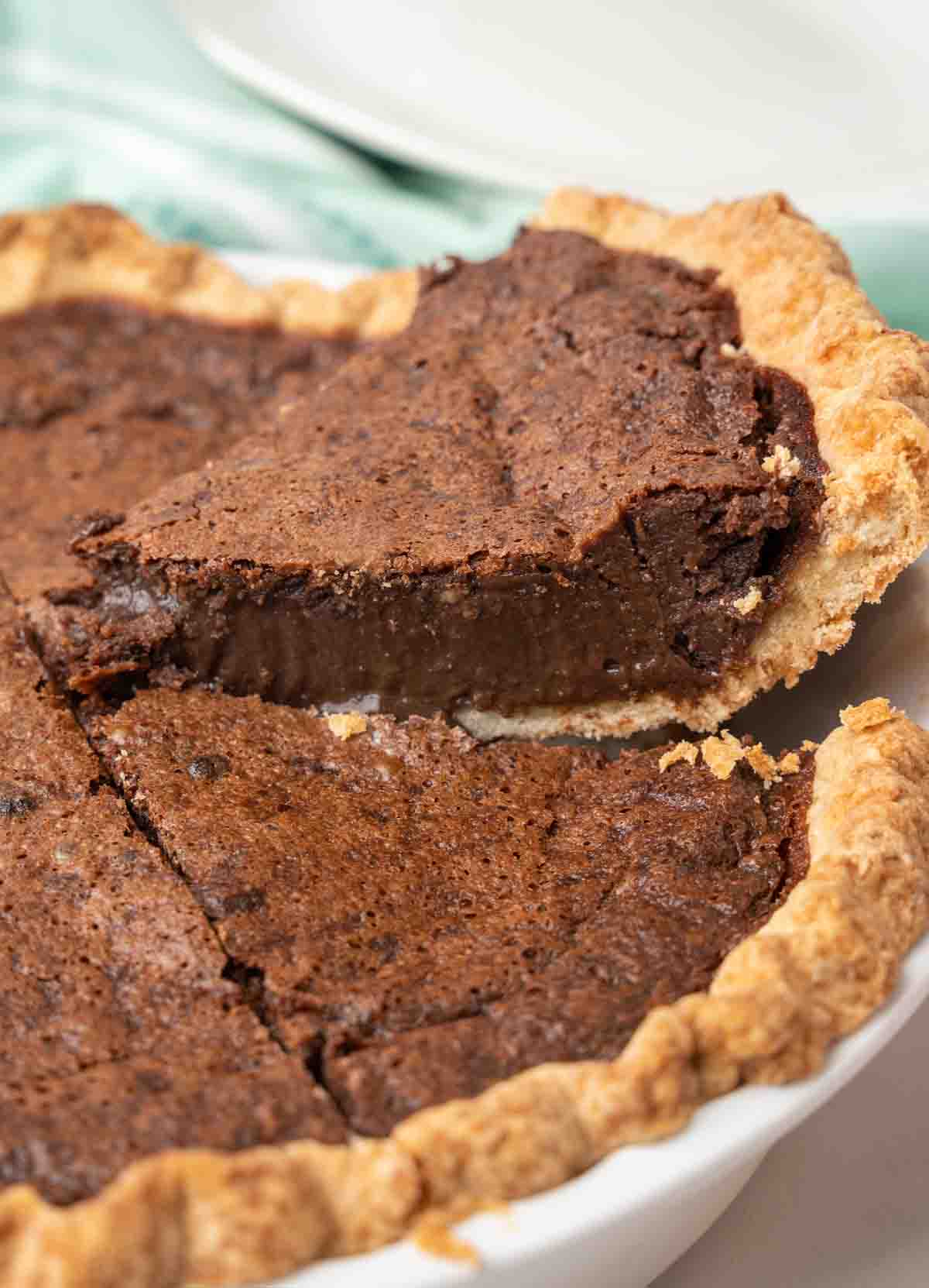 slice being taken out on a spatula of chocolate chess pie.