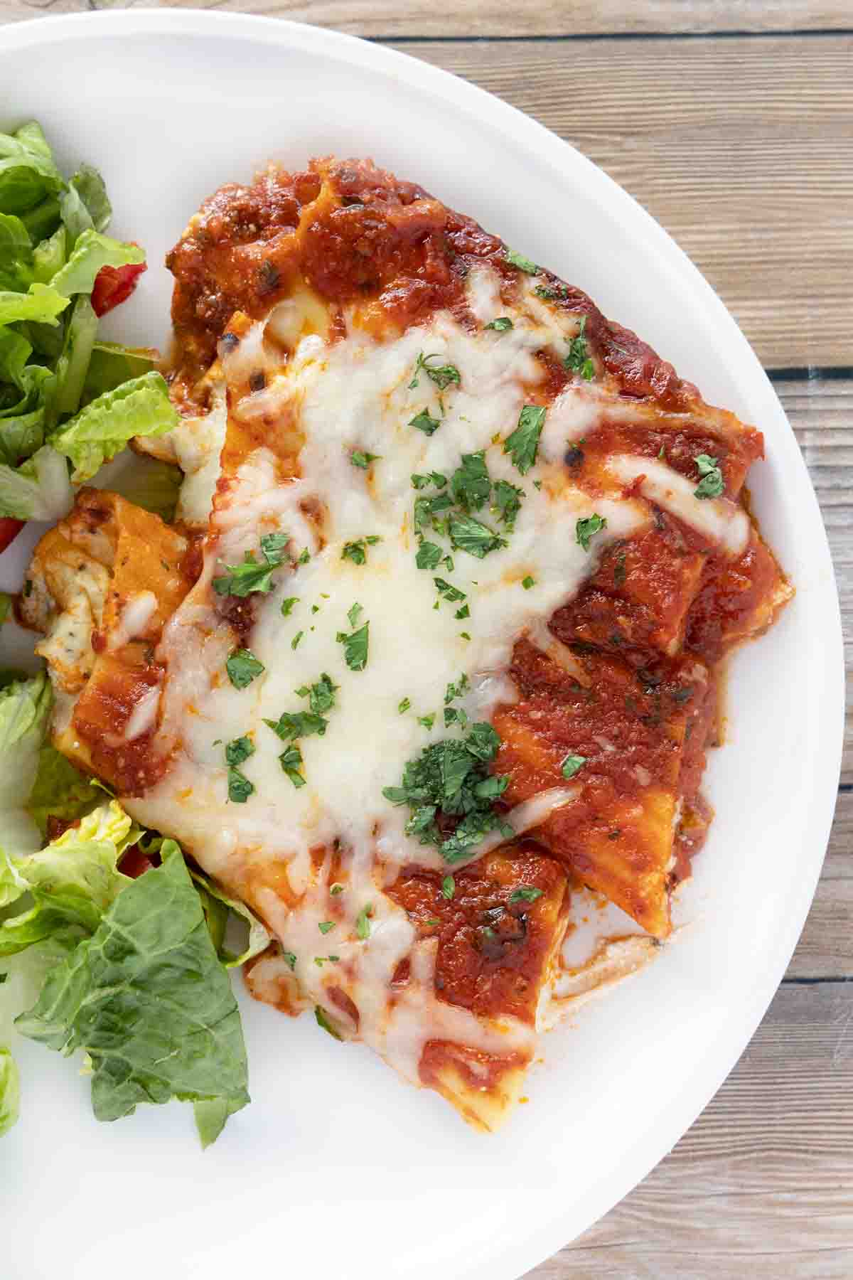 baked cheese manicotti on a white plate.