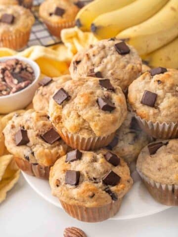 Banana chocolate chunk muffins on a white plate.