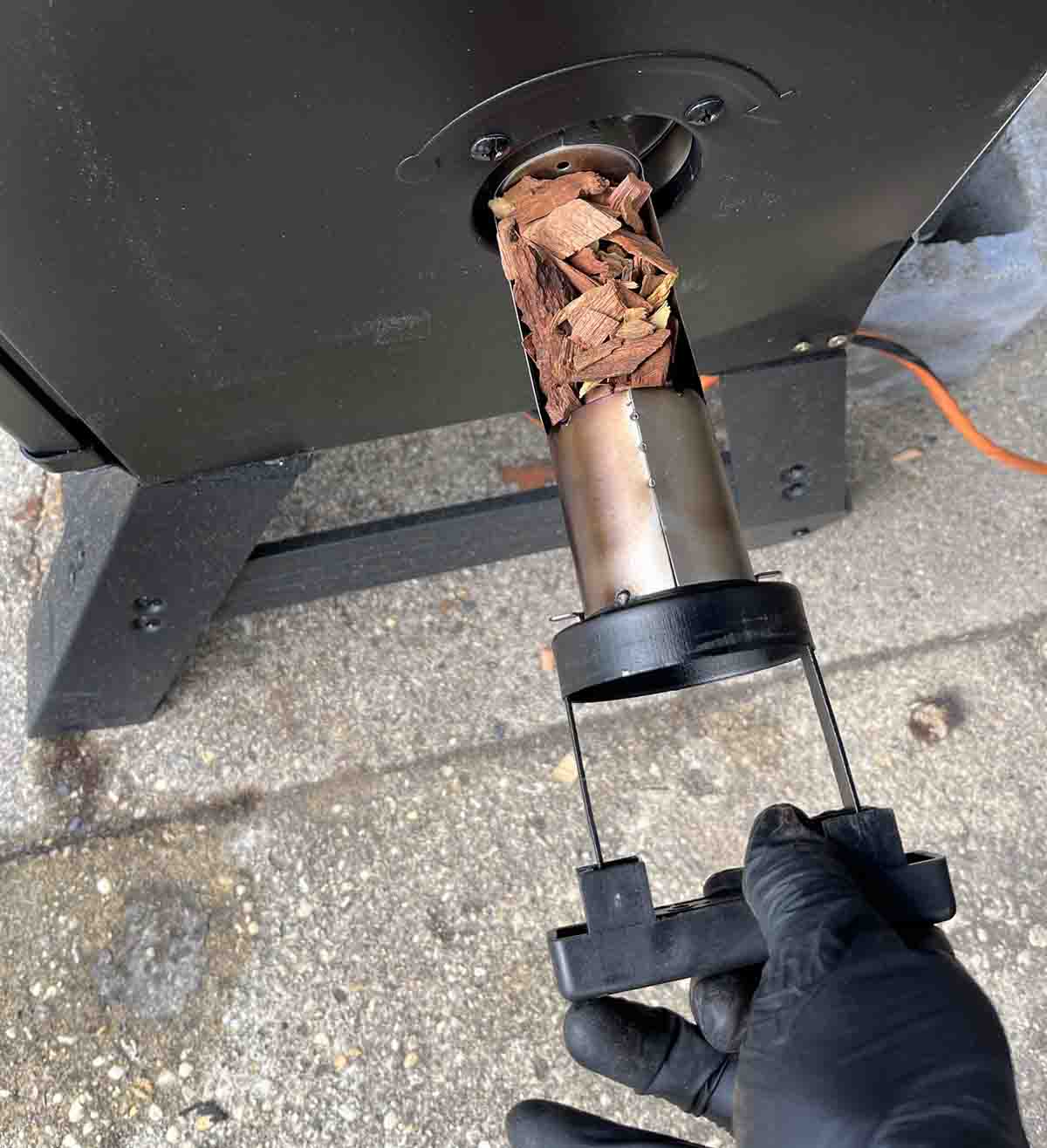 Adding wood chips to the smoker.