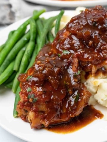 slow cooker chicken thighs on plate with green beans.