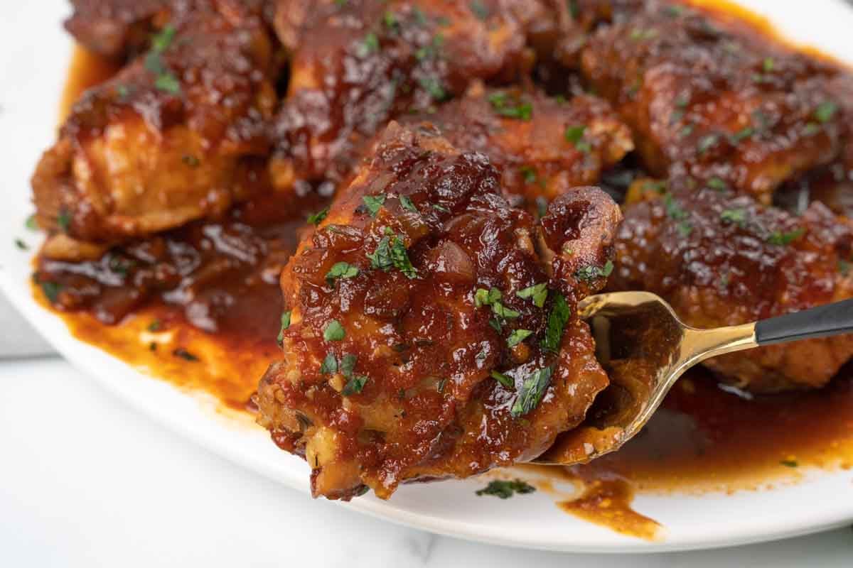 slow cooker chicken thighs on white platter.