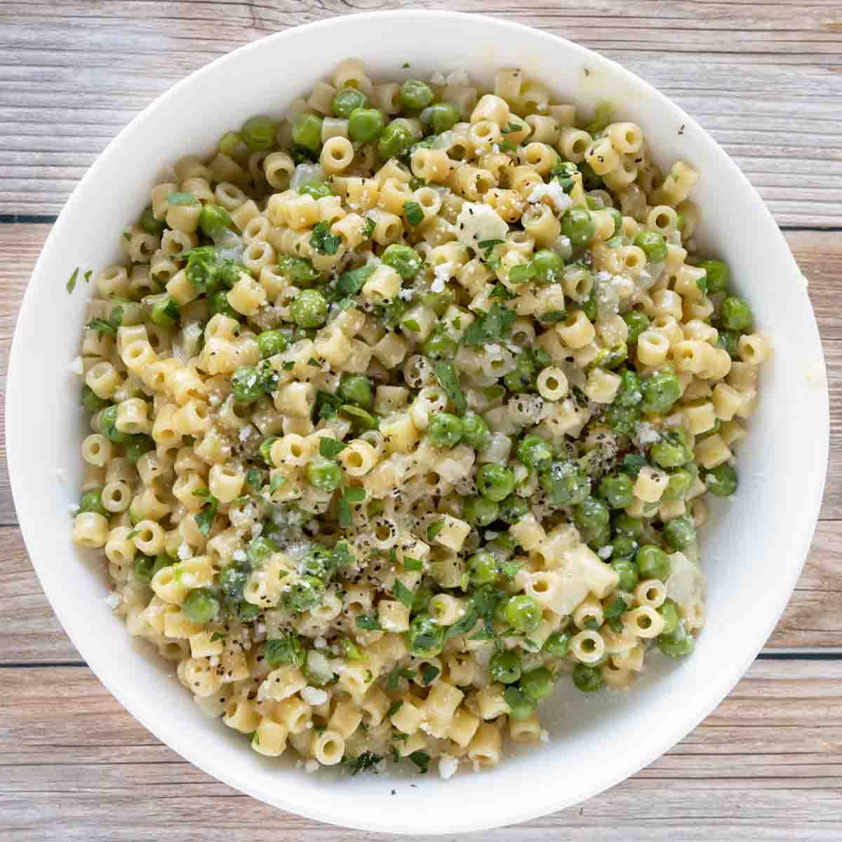 pasta e piselli (pasta with peas) in a white bowl.