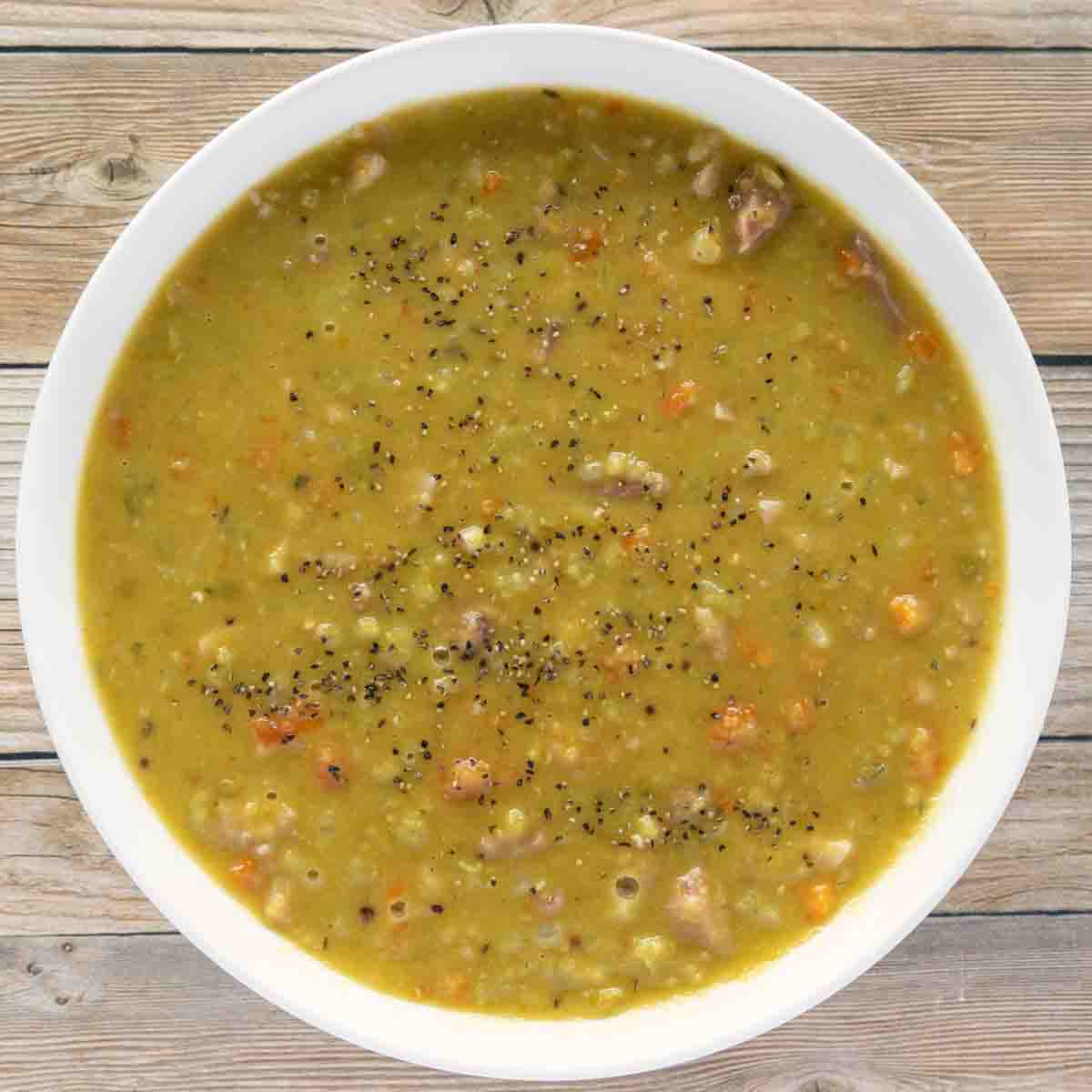 split pea soup with ham in a white bowl.