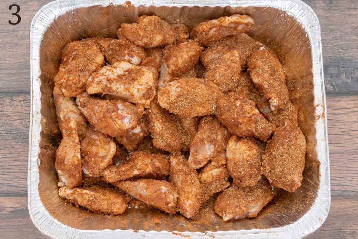 chicken wings with seasoning in an aluminum pan.