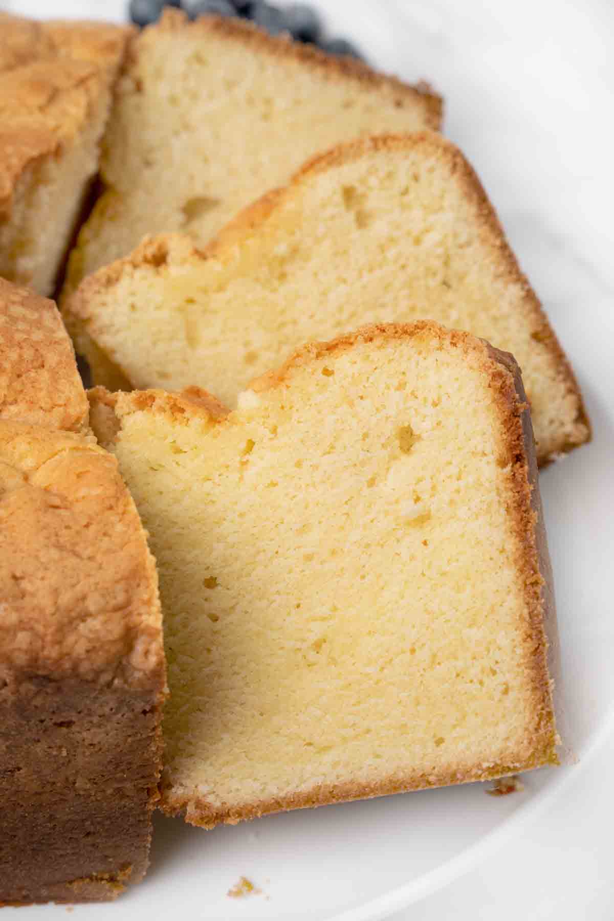 slices of sour cream pound cake on a white platter.