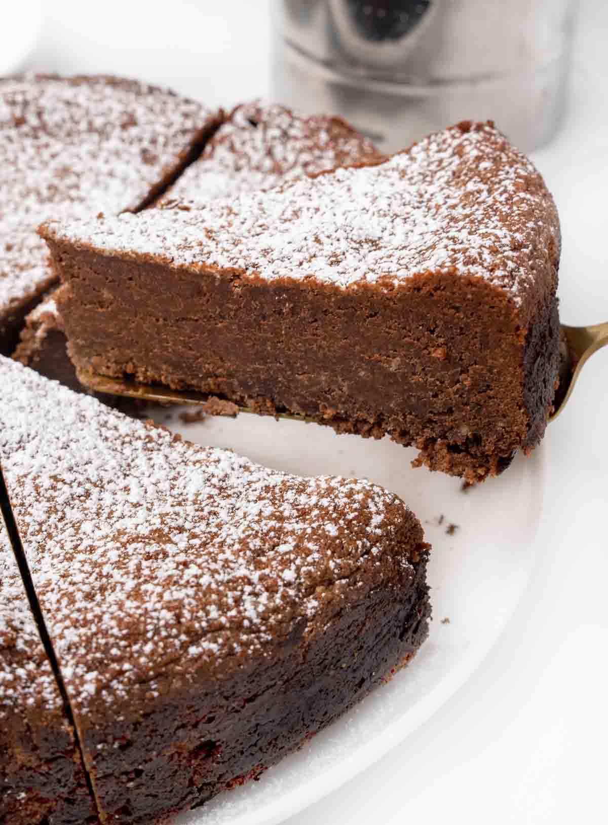 slice of torta caprese being taken out of the whole cake.