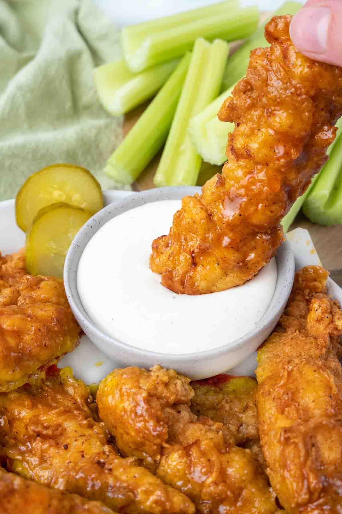 dipping a Nashville hot chicken tender into bleu cheese dressing.