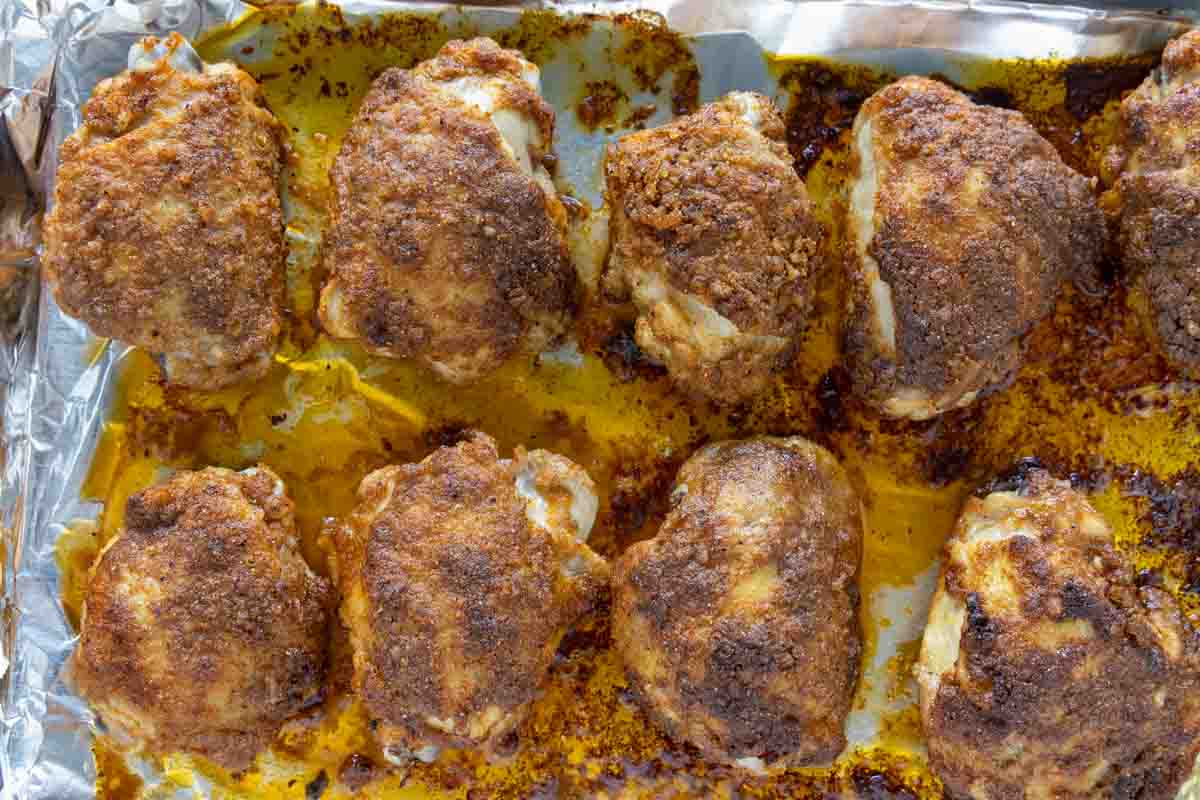 Baked Chicken thighs on a foil lined pan.