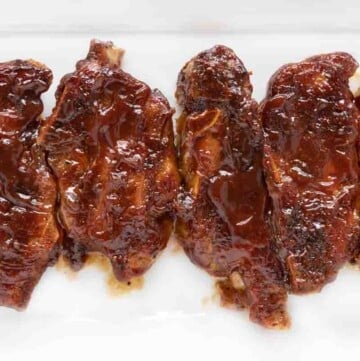 Barbecued country style pork ribs on a white platter