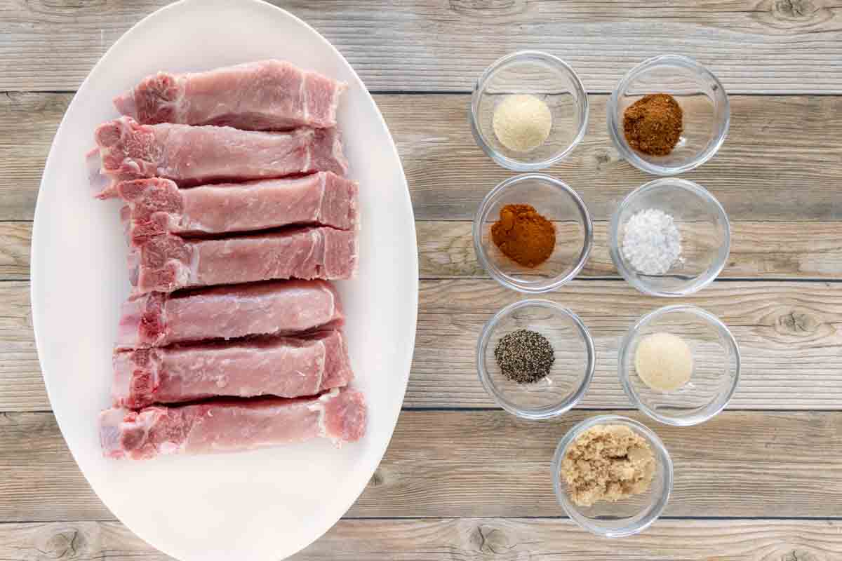 Ingredients required to make the pork recipe prepared on a wooden table.
