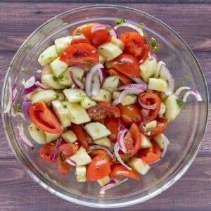 Cucumber tomato salad in a glass bowl.