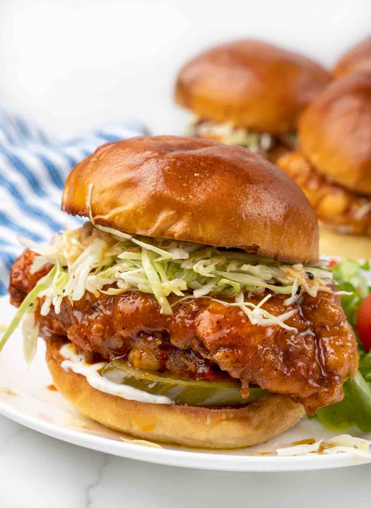 Nashville hot chicken sandwich on a white plate.