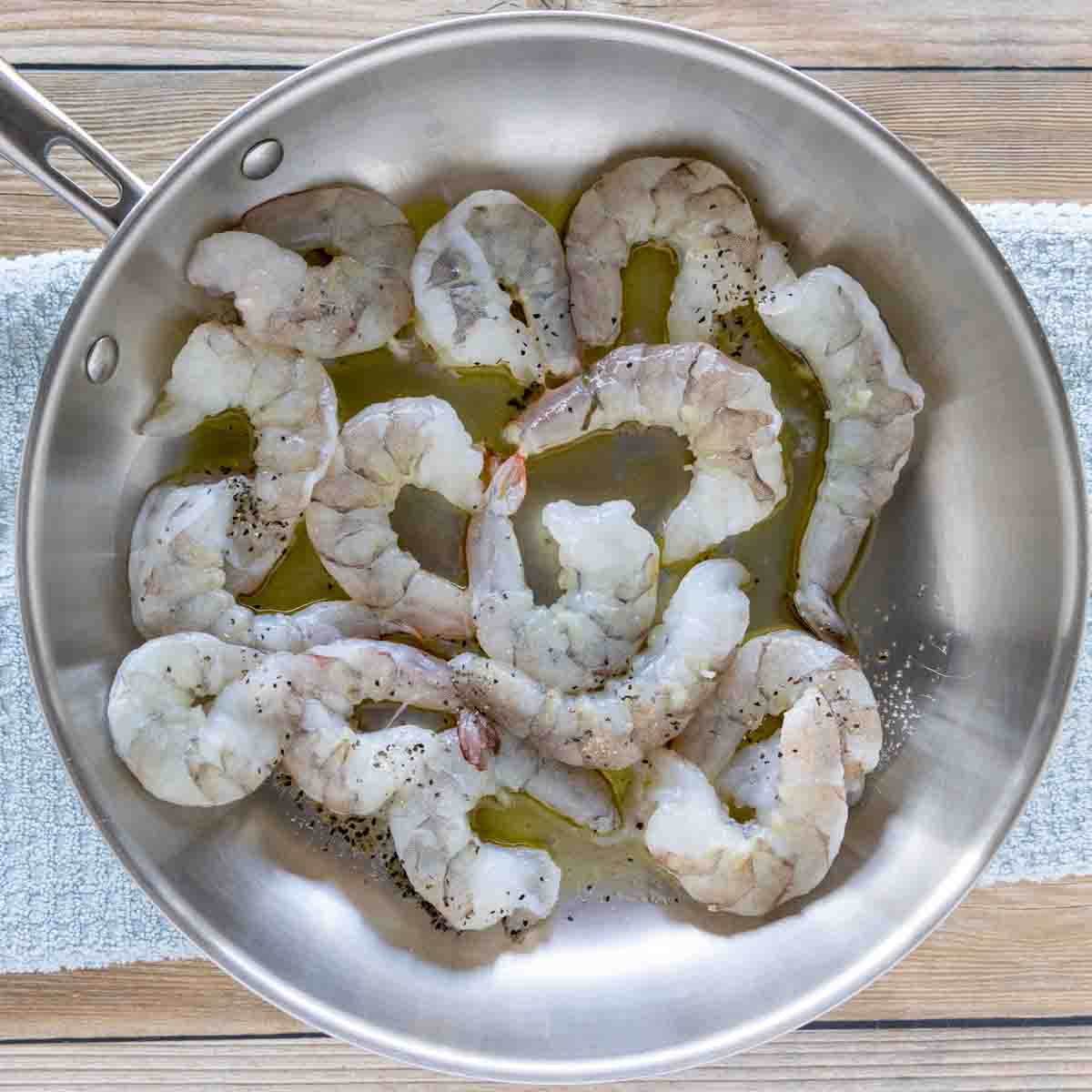 add olive oil and raw shrimp to the pan.