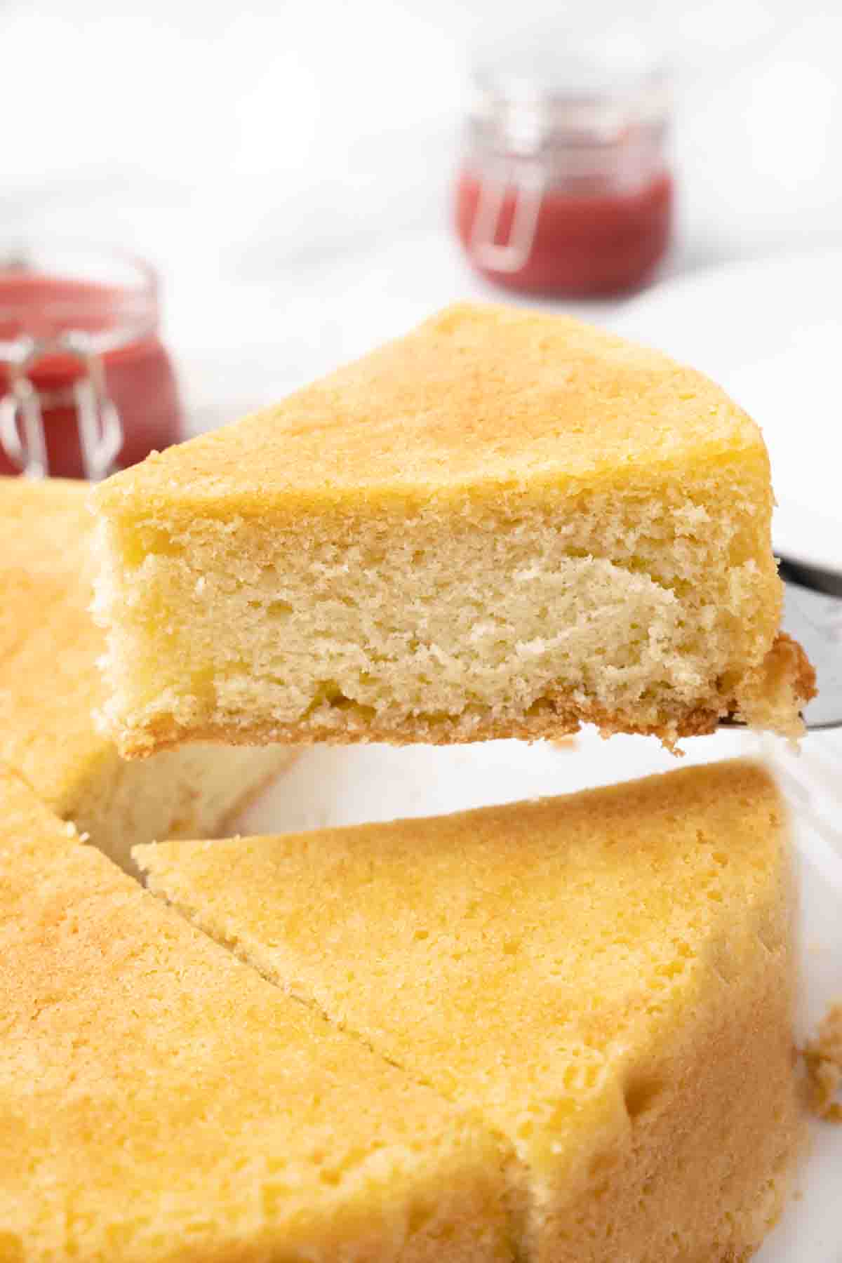slice being taken out of whole sponge cake.