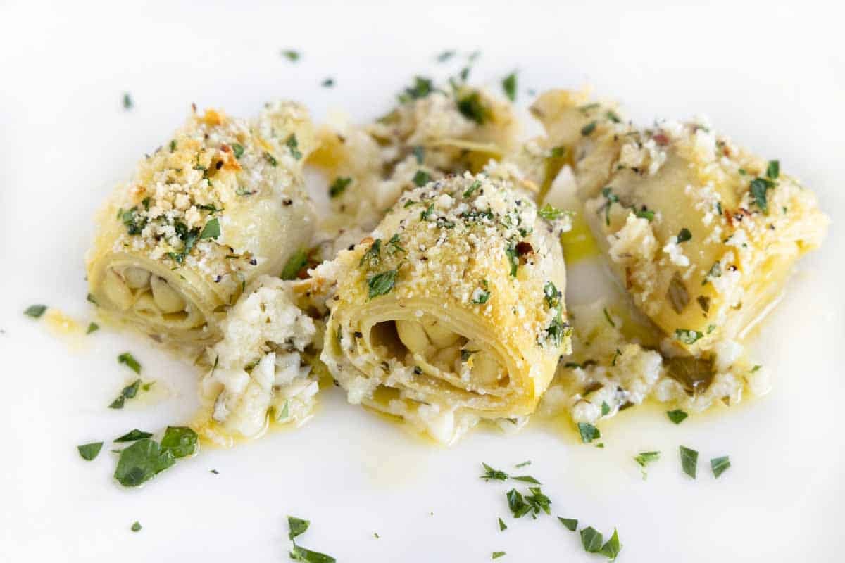 Baked artichoke hearts on a white plate.