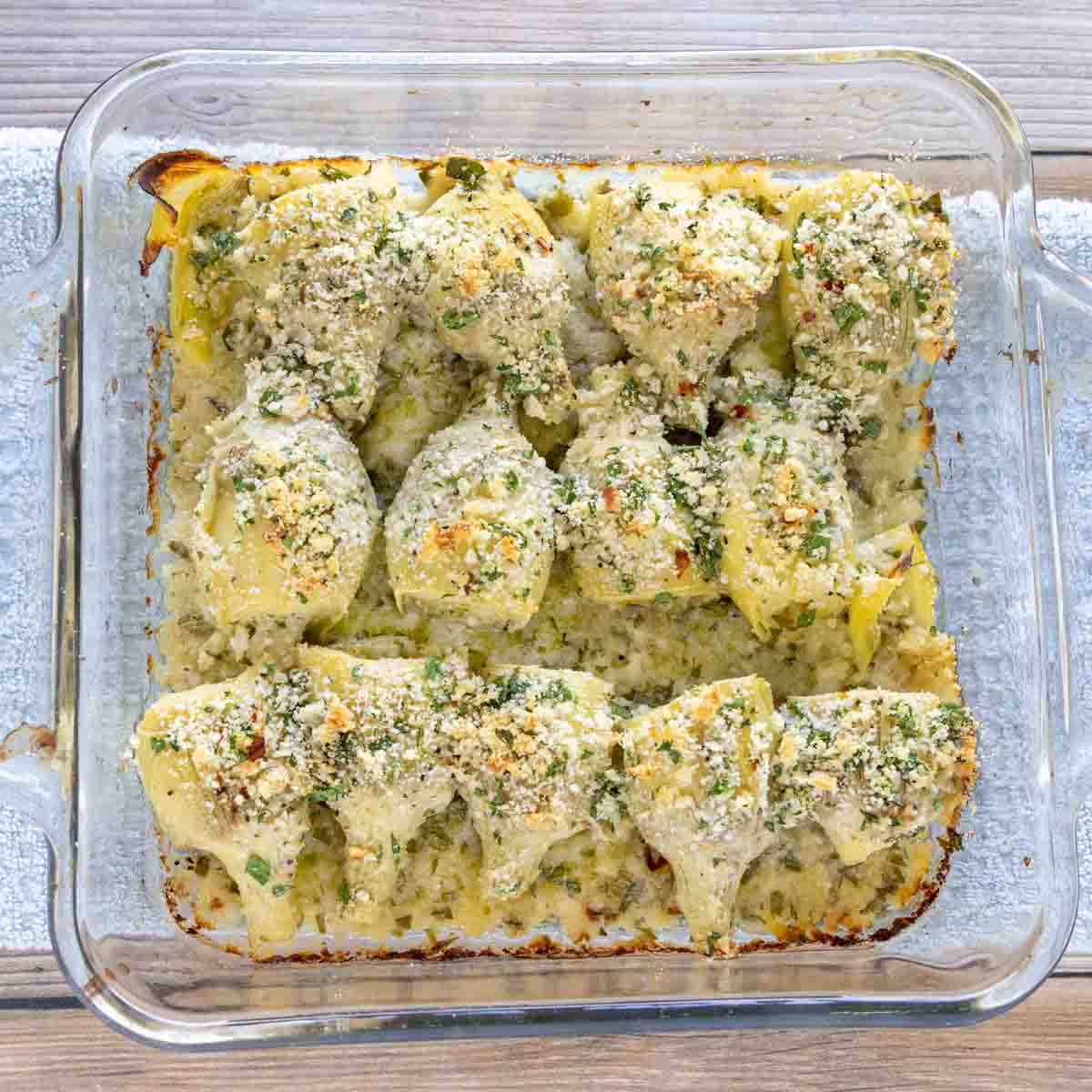 Baked artichoke hearts in a baking dish.