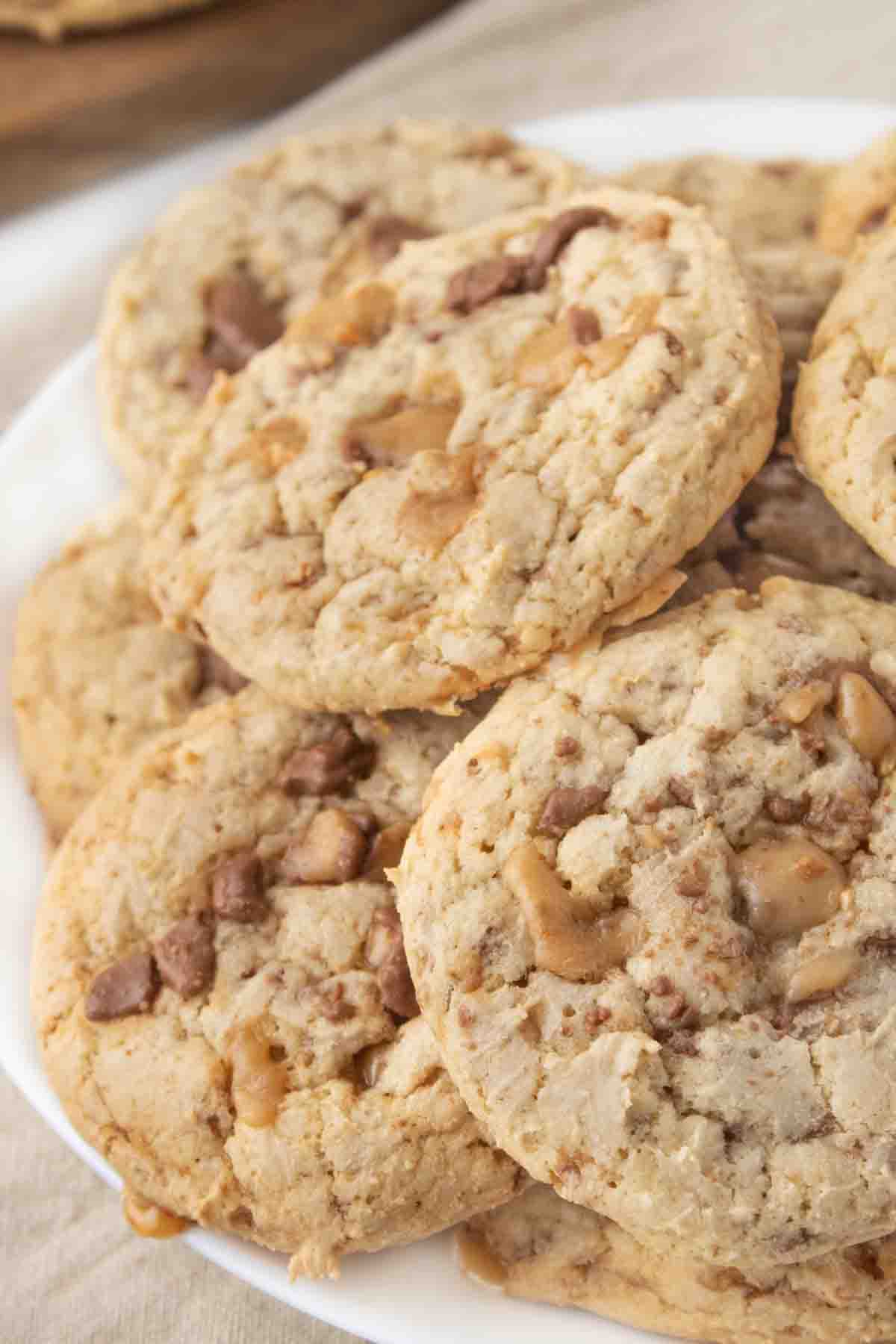 heath bar cookies stacked on a white plate.