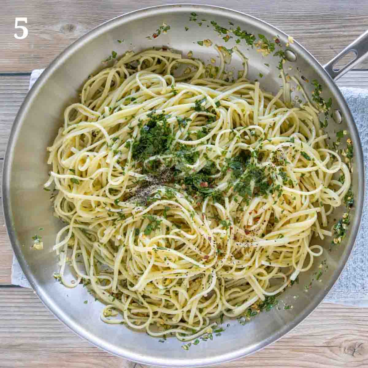 pasta in pan with additional parsley and pasta water.