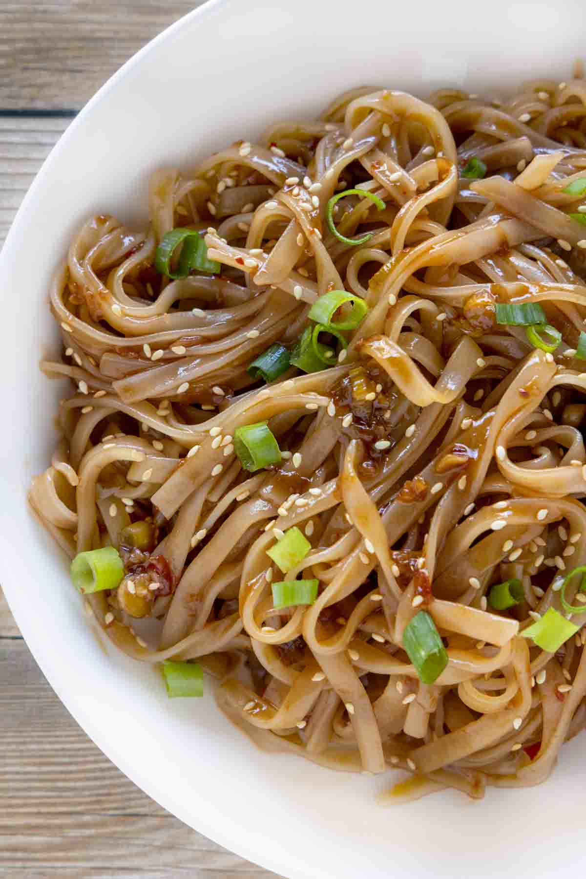 spicy chili garlic noodles in a white bowl.